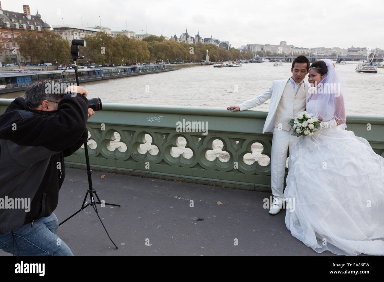 A Chinese couple have wedding photographs taken by the River Thames in London, England, UK Stock Photo