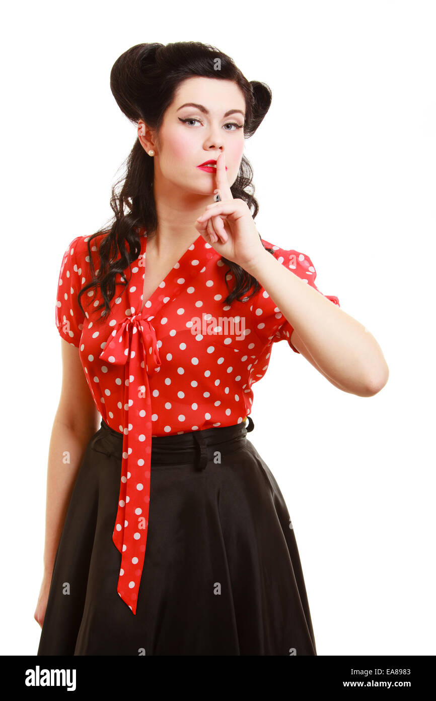 Retro style. Woman with finger on lips hush hand gesture isolated on white. Pinup brunette girl asking for silence or secrecy. Stock Photo