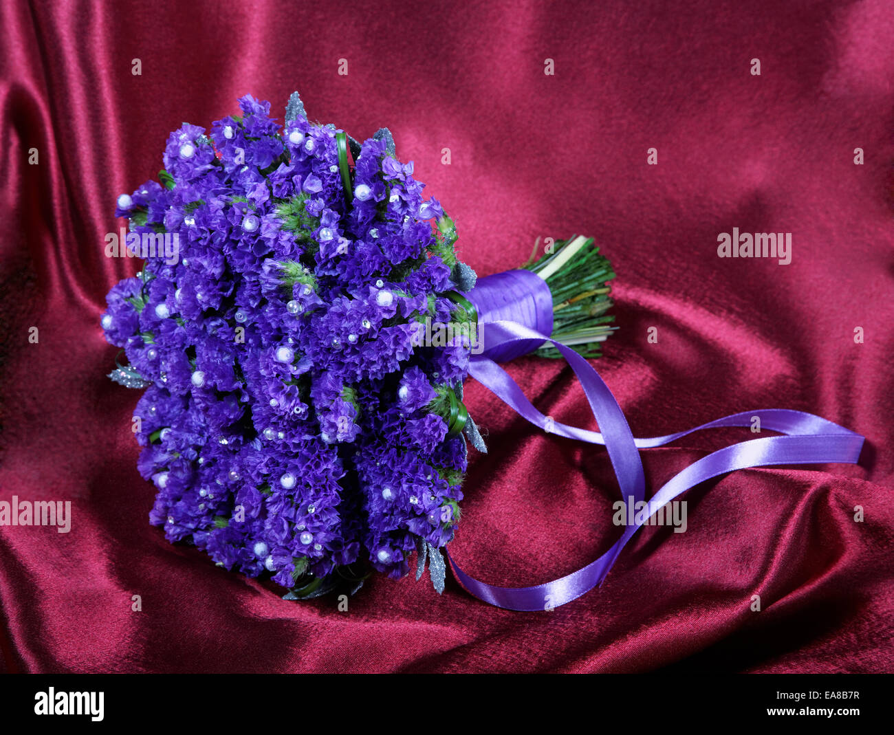 Wedding bouquet from violets on a red fabric Stock Photo