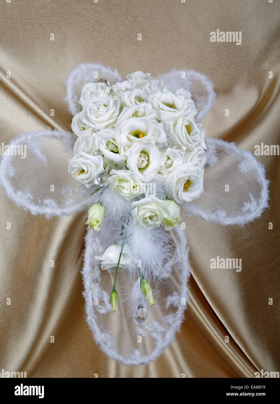 White wedding bouquet against a golden fabric Stock Photo
