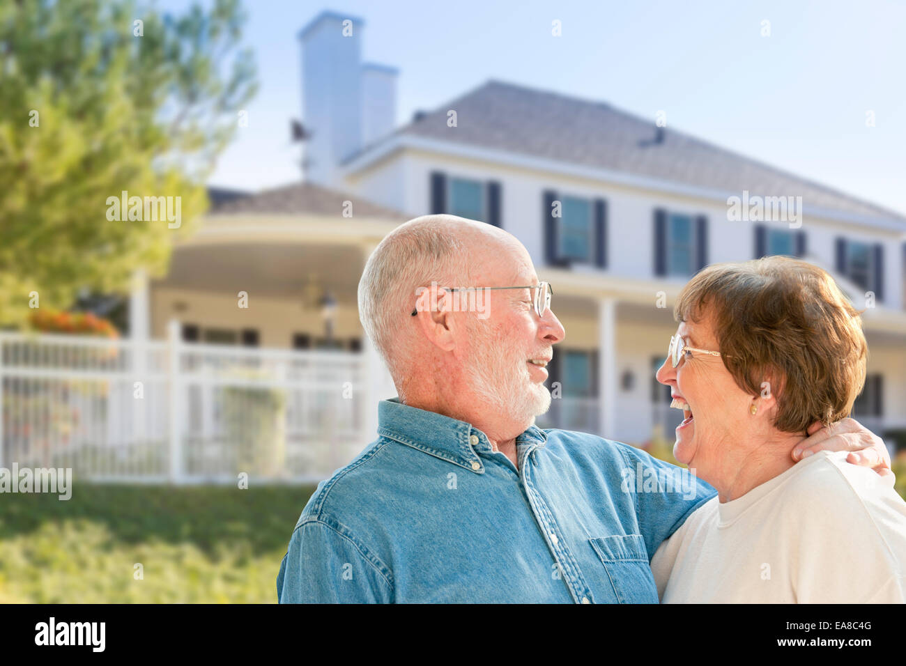 Happy Senior Couple in the Front Yard of Their House. Stock Photo