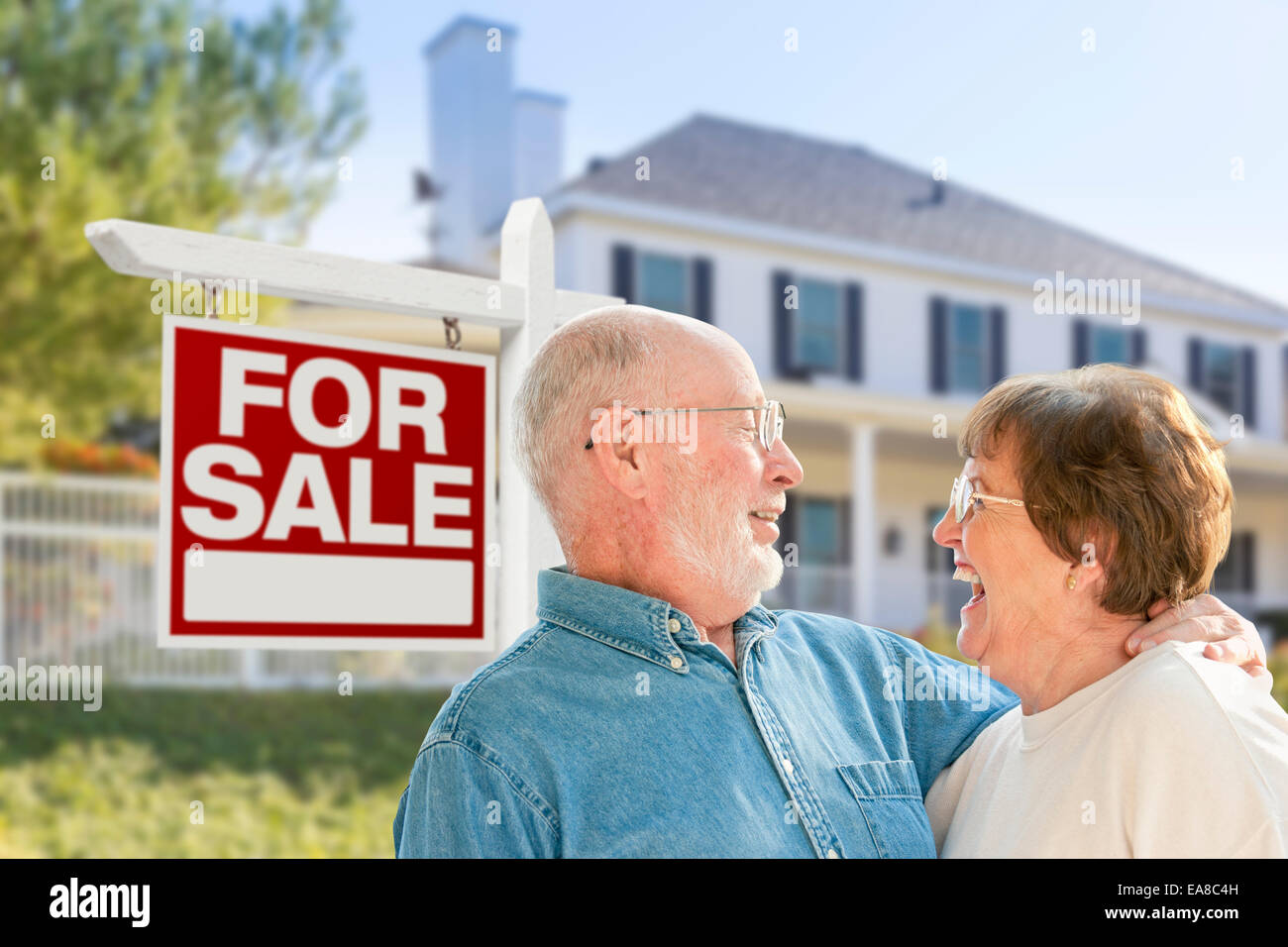 Happy Senior Couple Front of For Sale Real Estate Sign and House Stock ...