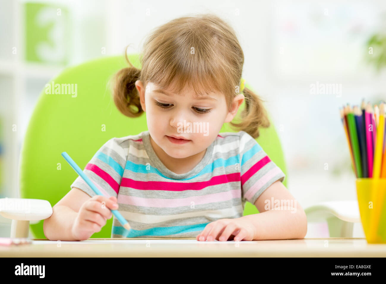 cute little girl drawing with colourful pencils Stock Photo - Alamy