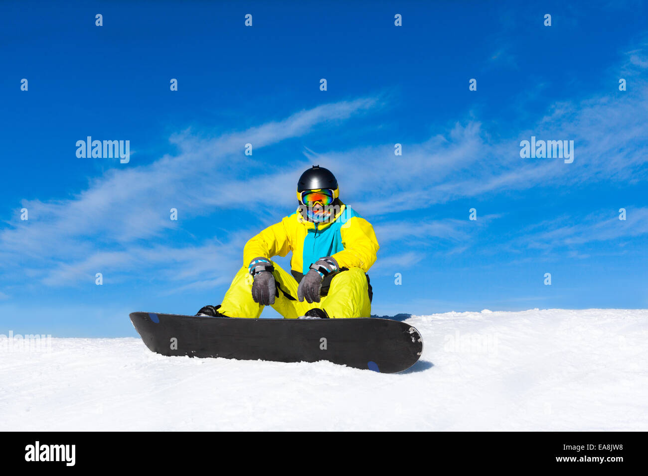snowboarder sitting on snow mountain slope Stock Photo