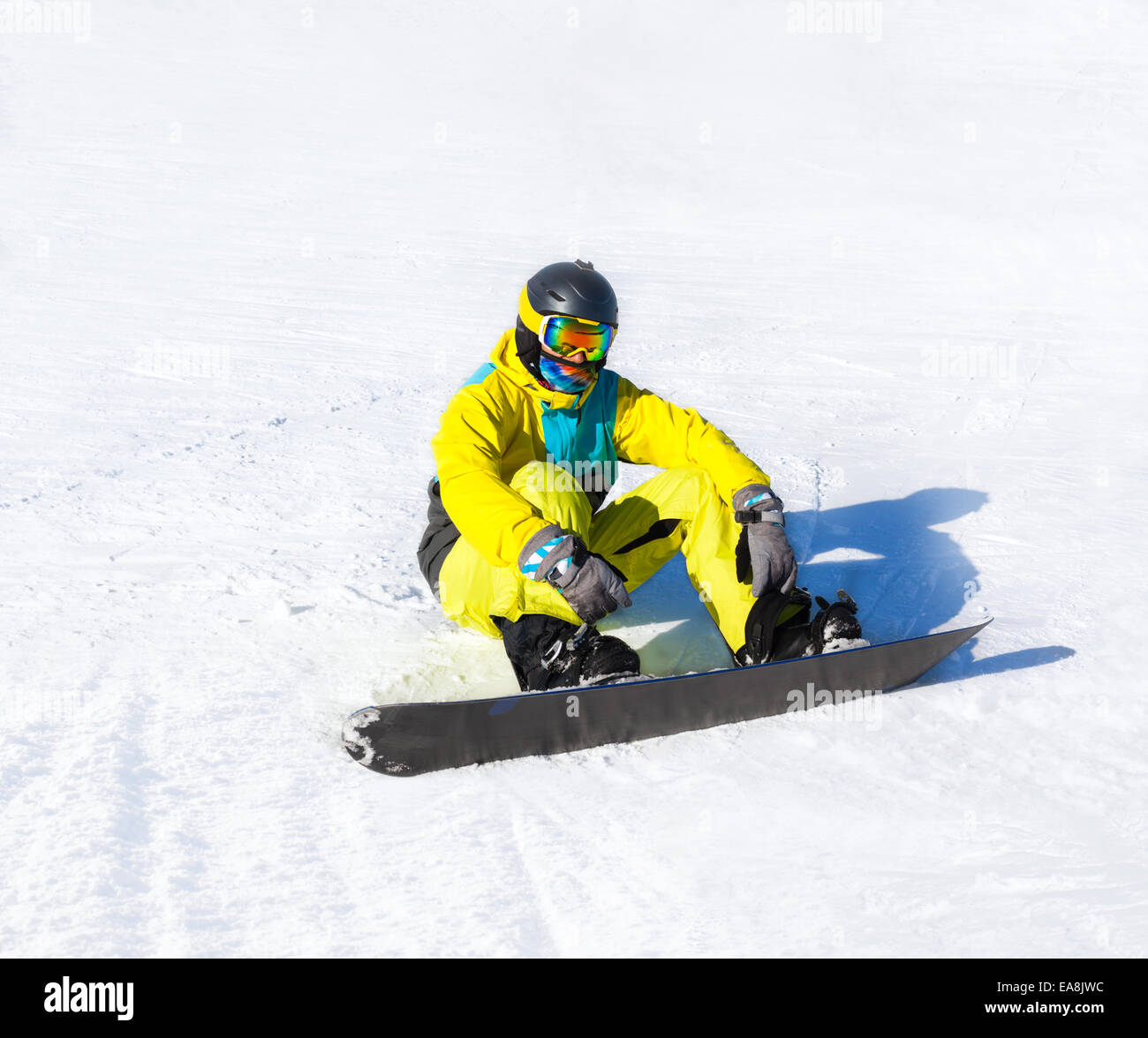 Snowboarder sitting on snow mountains Stock Photo