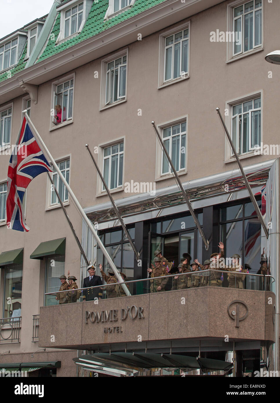 Celebrating raising the Union Jack on the Pomme d'Or balcony  Liberation Day Parade at St Helier Stock Photo