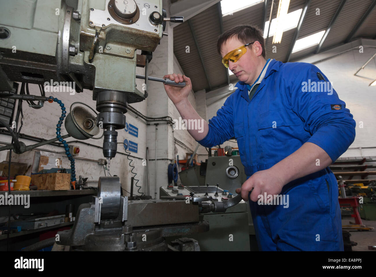 Engineer on a drilling machine tool used in the manufacture of hydraulic parts Stock Photo