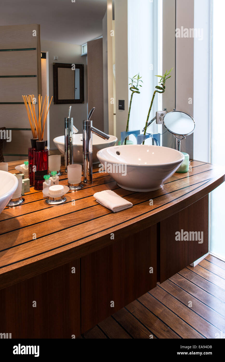 washbasin on a wooden shelf in a luxurious bathroom in a hotel room