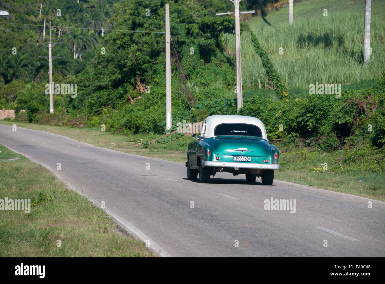A vintage American car used as a taxi travels down a rural road near Jibacoa Cuba Stock Photo