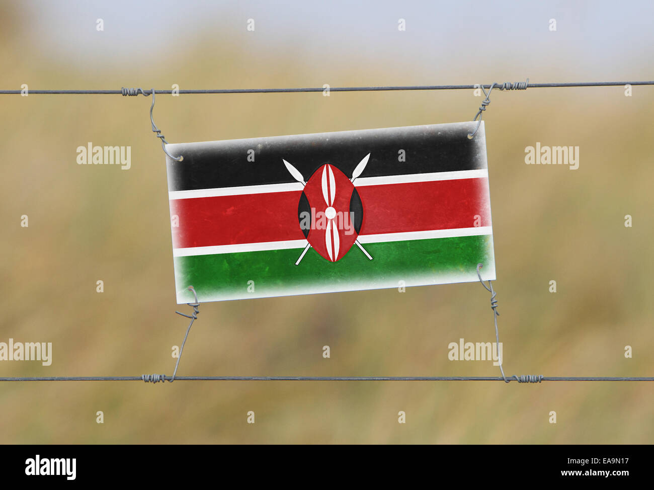 Border fence Old plastic sign with a flag Kenya Stock Photo Alamy
