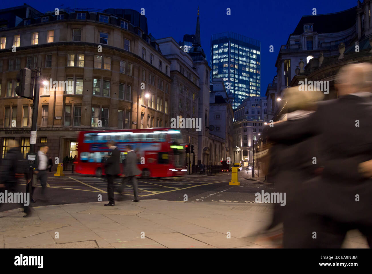 Streets of the City of London at night - motion blur for unrecognisable people - location is junction of Lothbury and Moorgate. Stock Photo