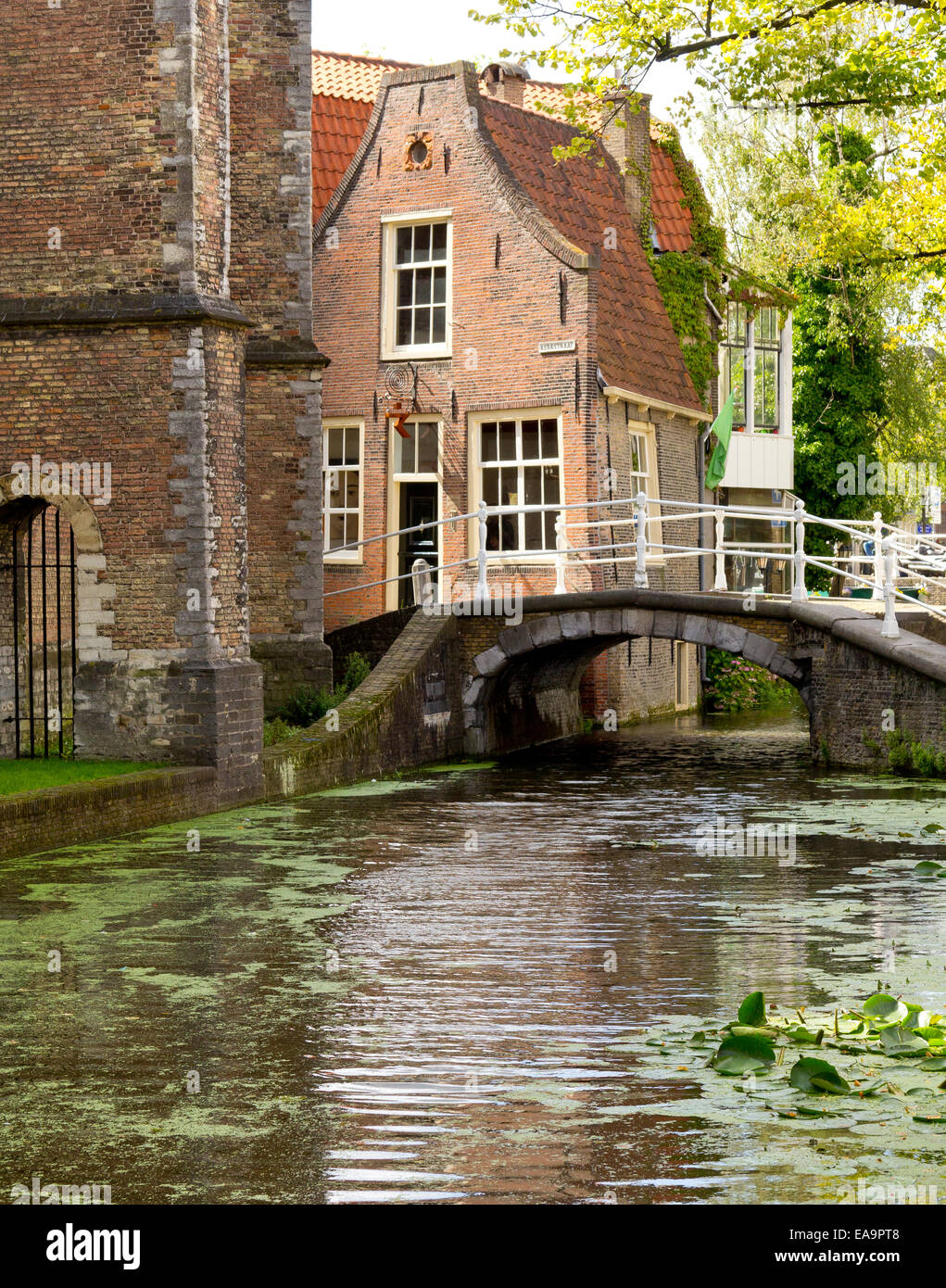 Footbridge over a canal in the centre of Delft, Netherlands, just behind the thick walls of the Nieuwe Kerk ('New' Church) Stock Photo