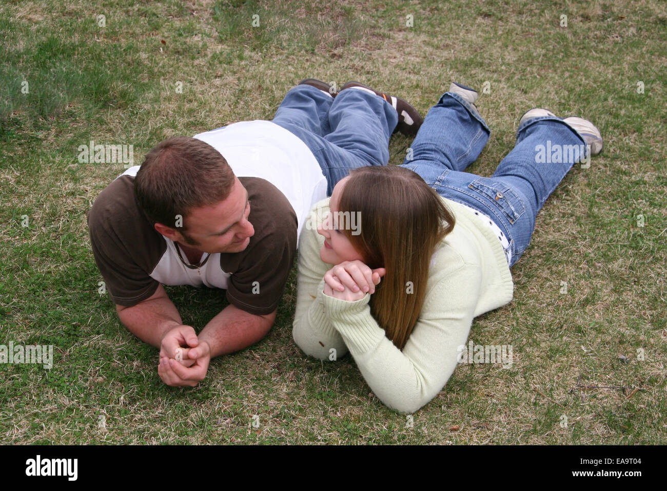 Young couple lying in grass Stock Photo - Alamy