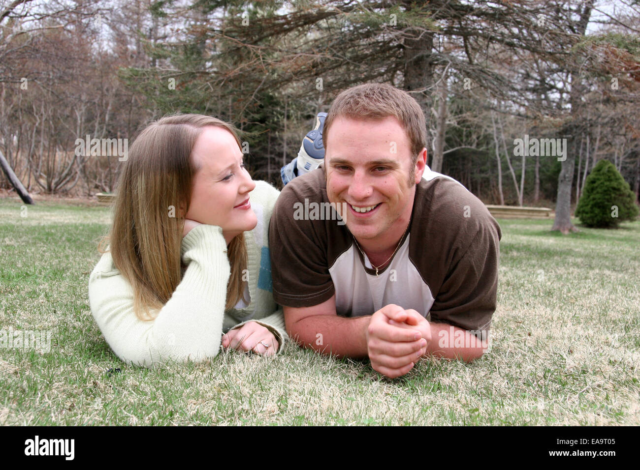 Happy Young couple lying in grass Stock Photo - Alamy