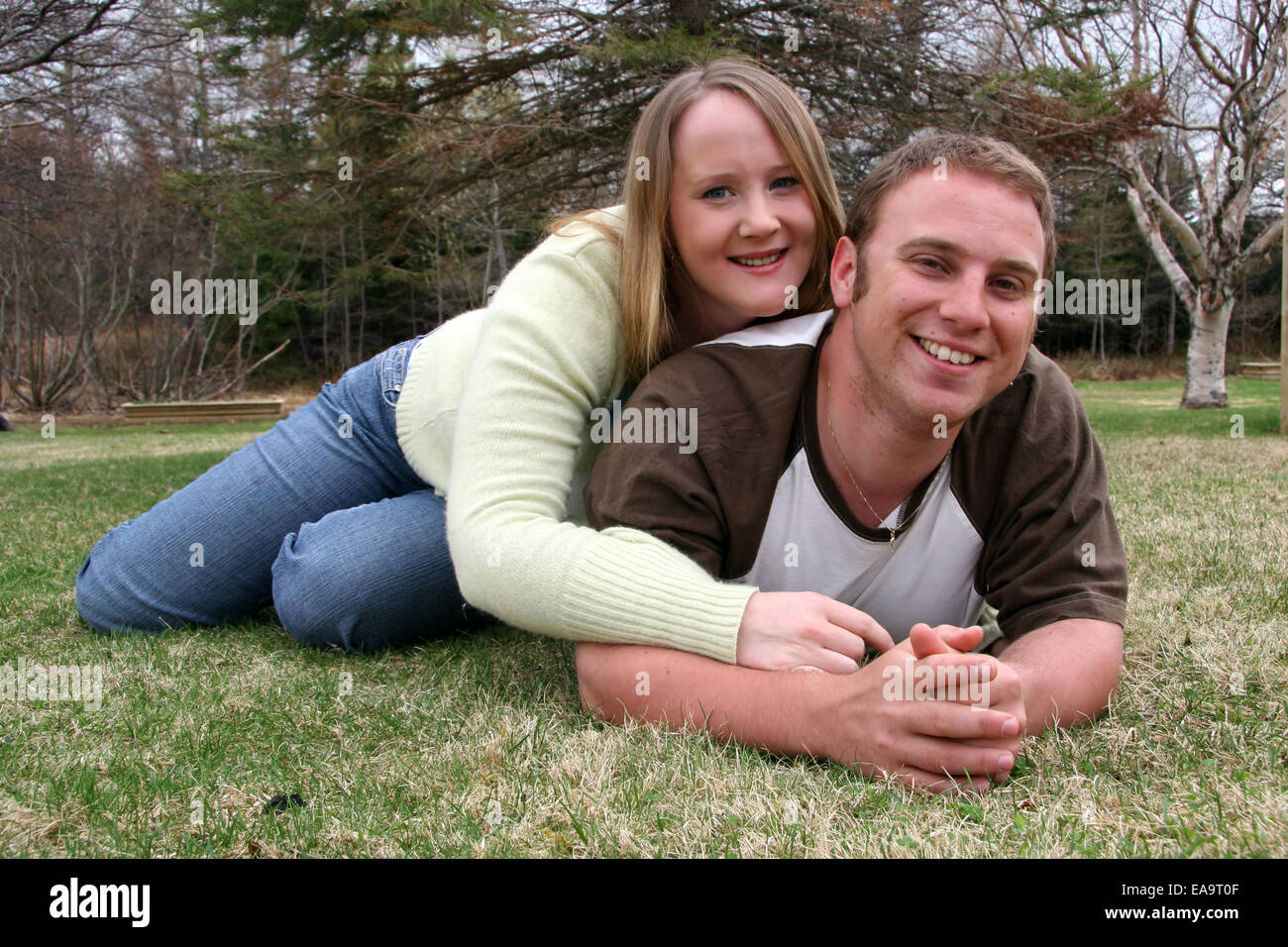 Young couple lying in grass Stock Photo - Alamy