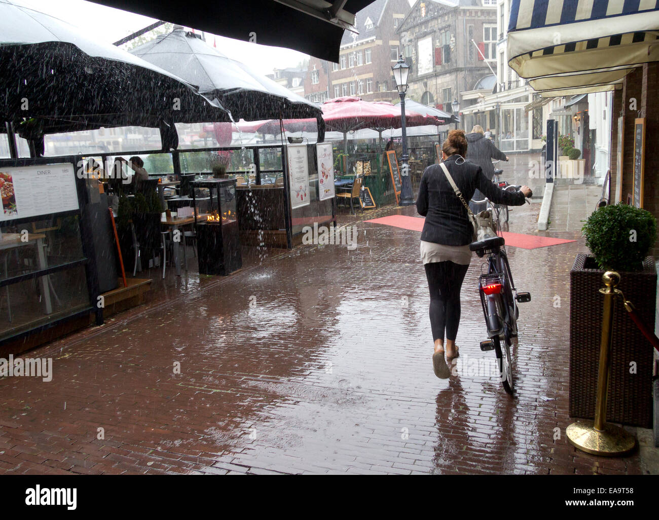 Cafes in the Markt (market place) Gouda, South Holland, The Netherlands during a torrential downpour of rain. Stock Photo