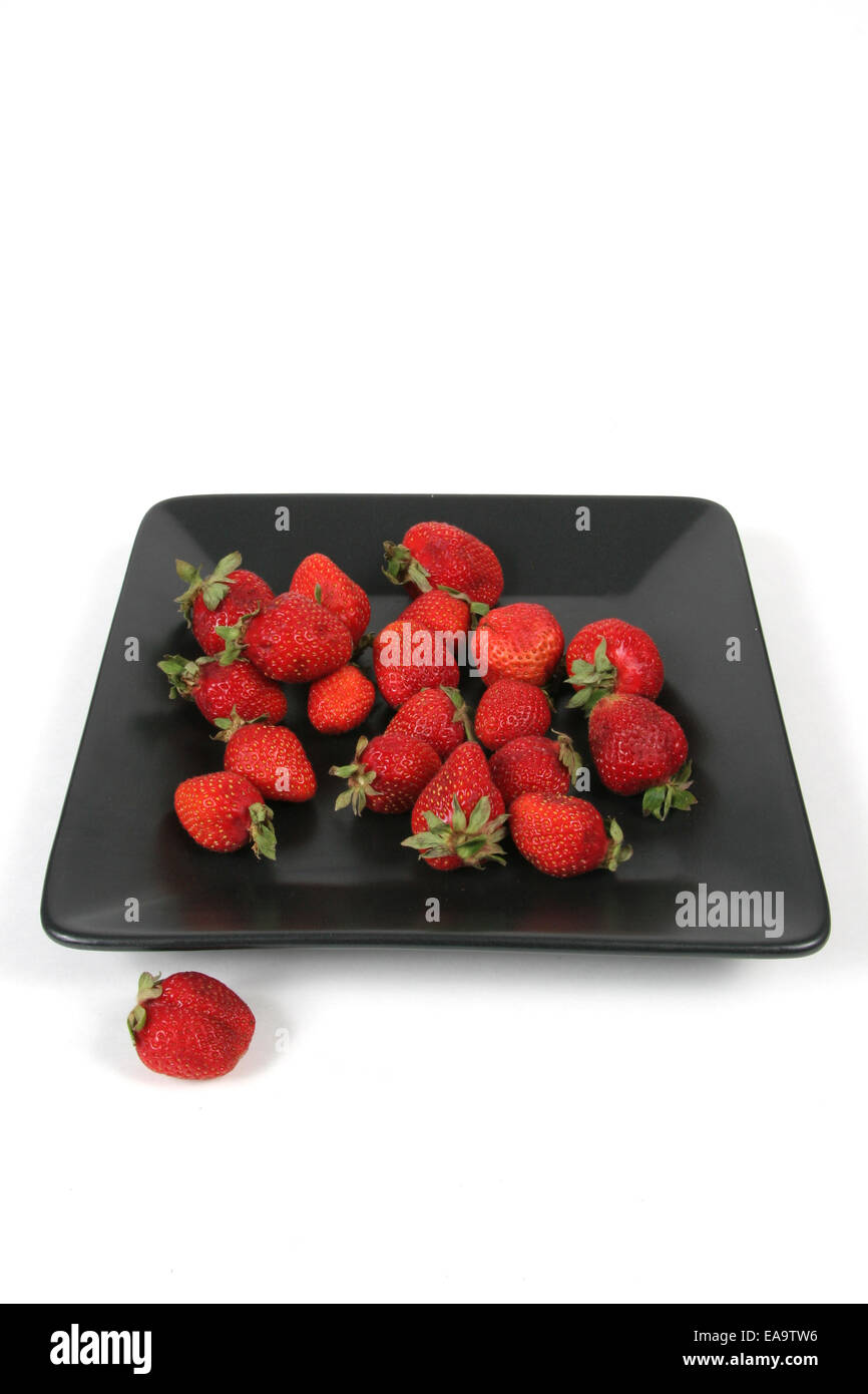 Strawberries over black plate hi-res stock photography and images - Alamy