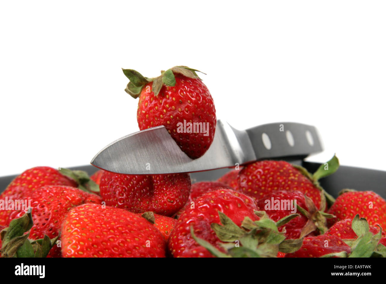 strawberries on Black Plate over White with knife Stock Photo - Alamy