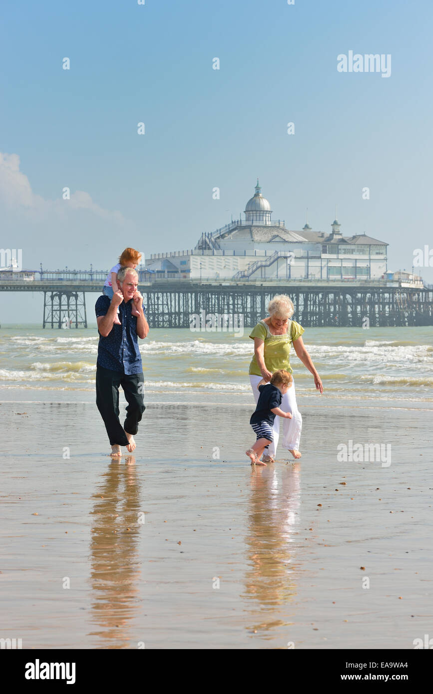 Grandparents with grandchildren on Eastbourne beach at low tide. East Sussex. UK Stock Photo