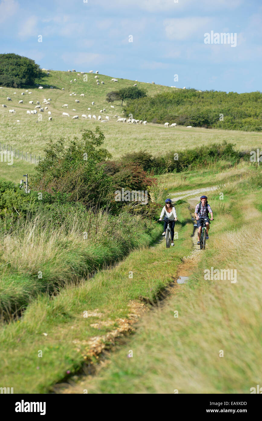 A young adult couple cycling along the South Downs Way at Butts Brow, Willingdon, near
