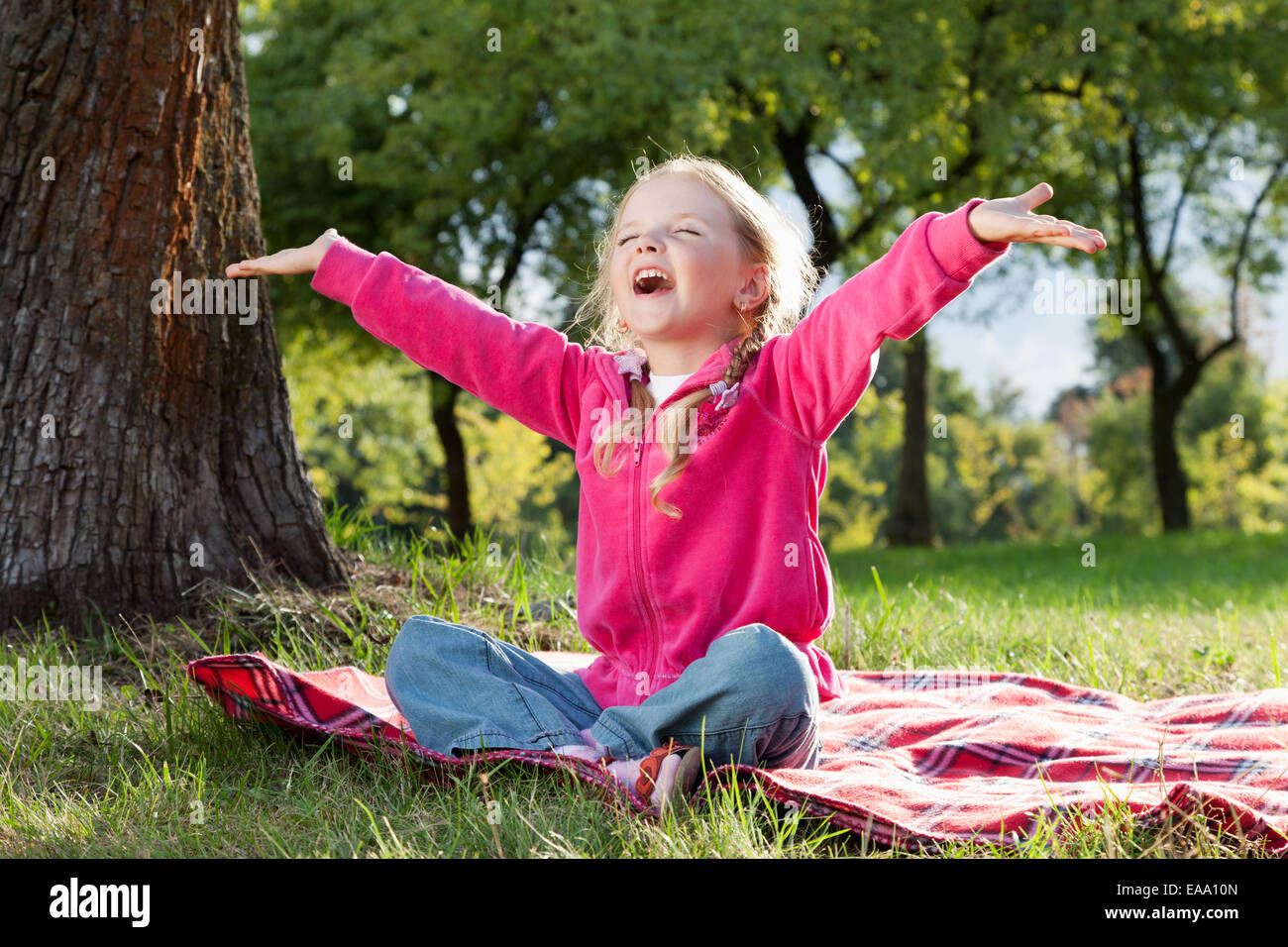 happy little girl with hands up in summer park Stock Photo - Alamy