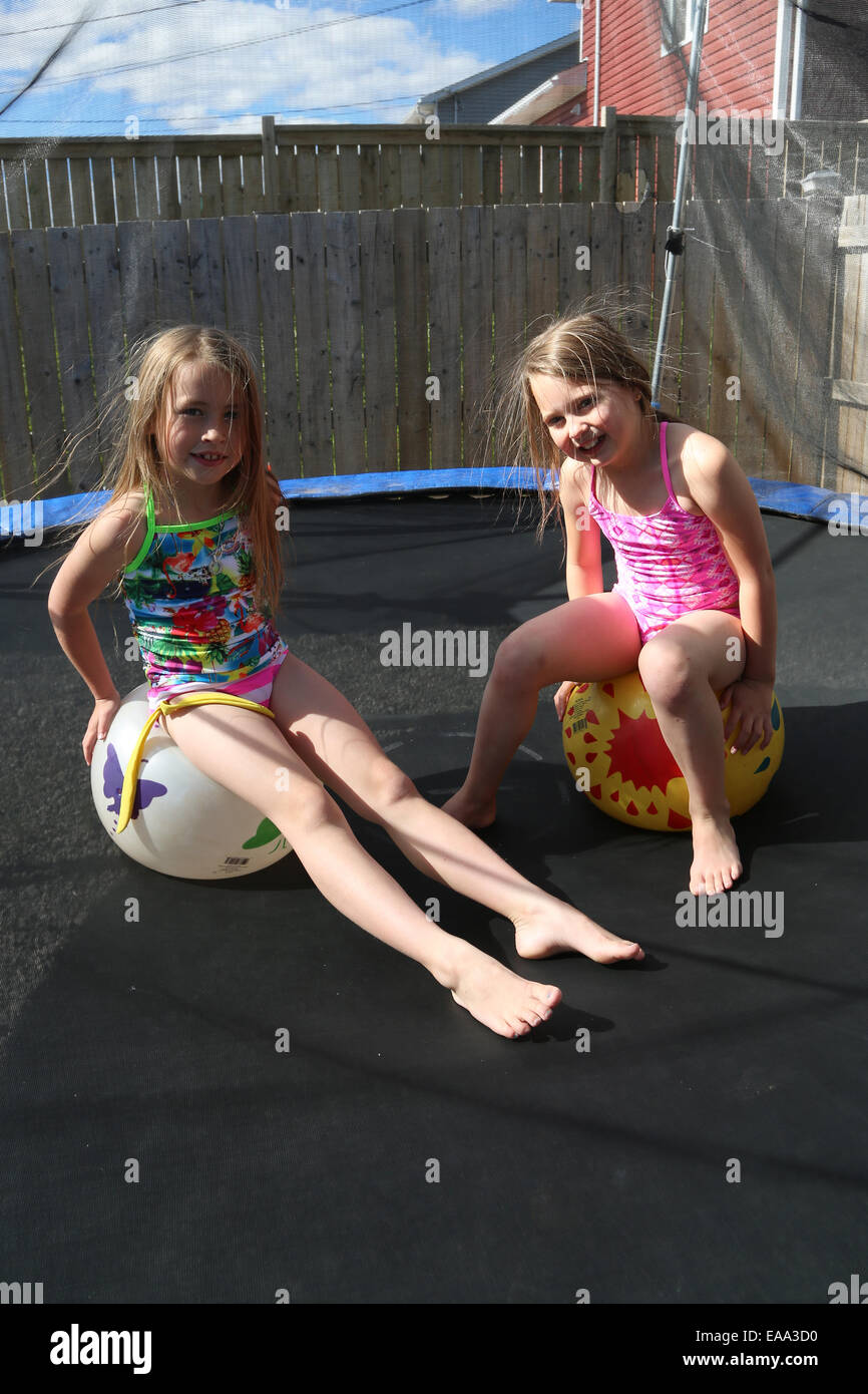 Children jumping on a trampoline in summer in there back yard Stock Photo -  Alamy