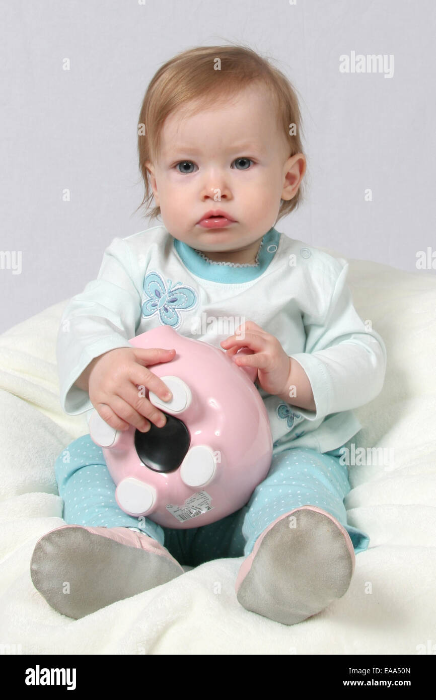 Little Girl Holding Piggy Bank in her hands Stock Photo - Alamy