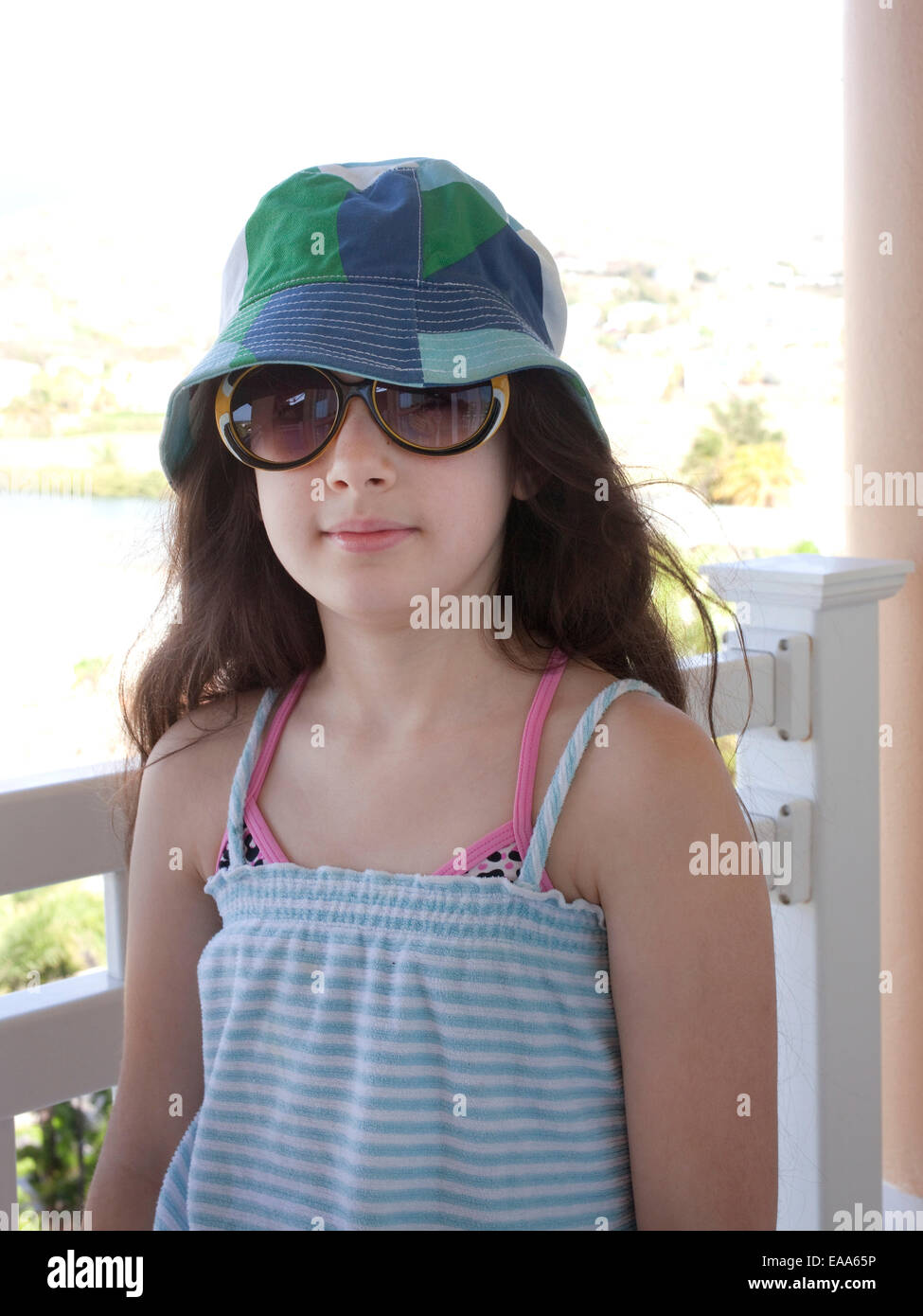 girl on beach vacation wearing hat and sunglasses Stock Photo