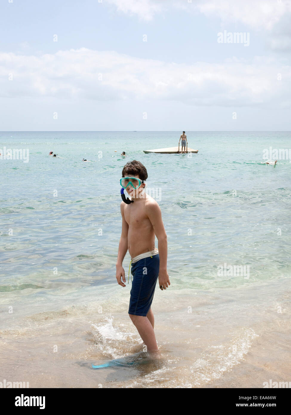 Teen boy in snorkel gear by water Stock Photo