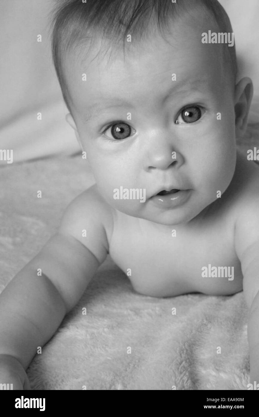 Little Baby Girl on belly in black and white Stock Photo