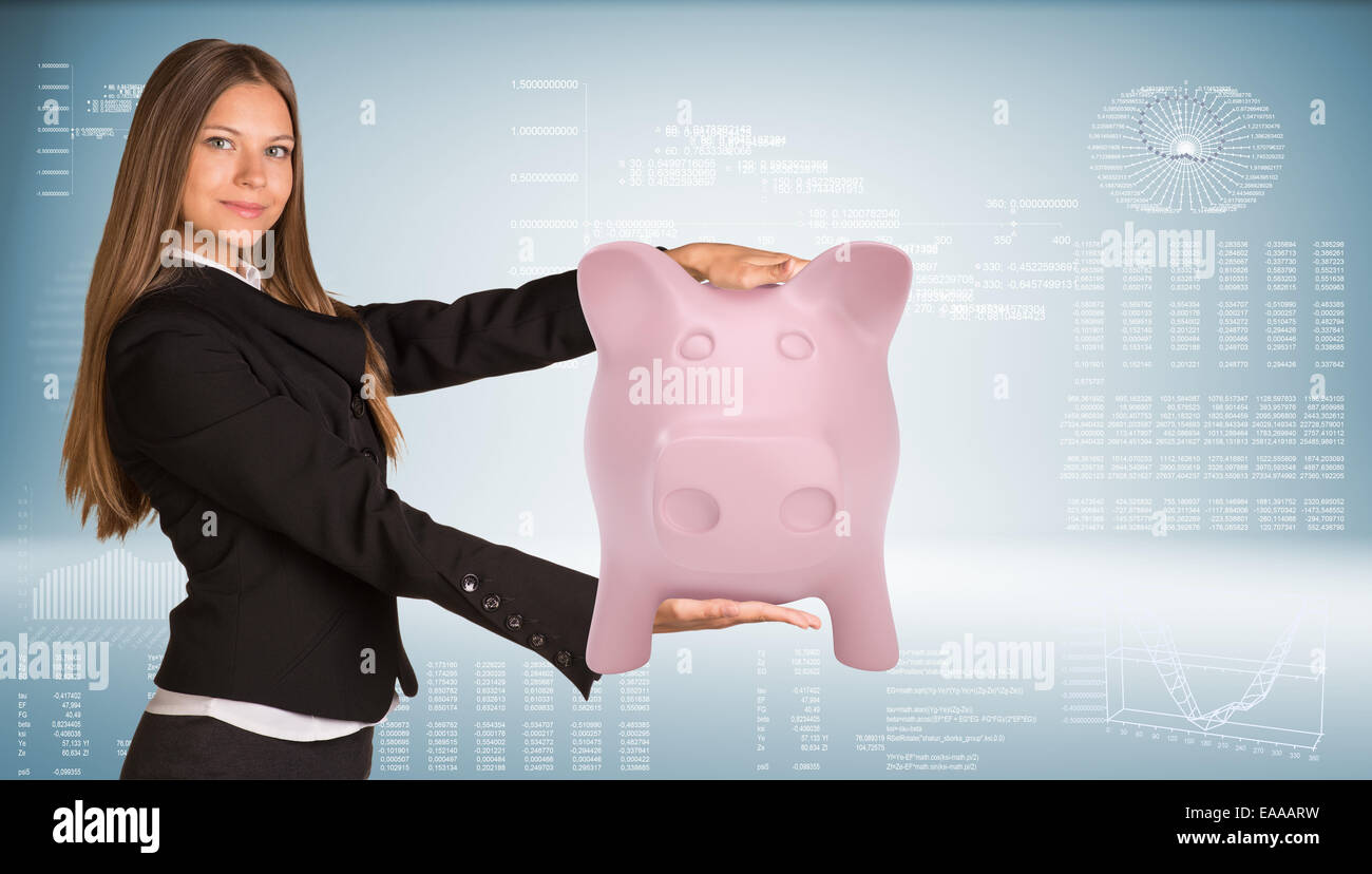 Beautiful businesswoman in suit smiling and holding pink piggy bank ...