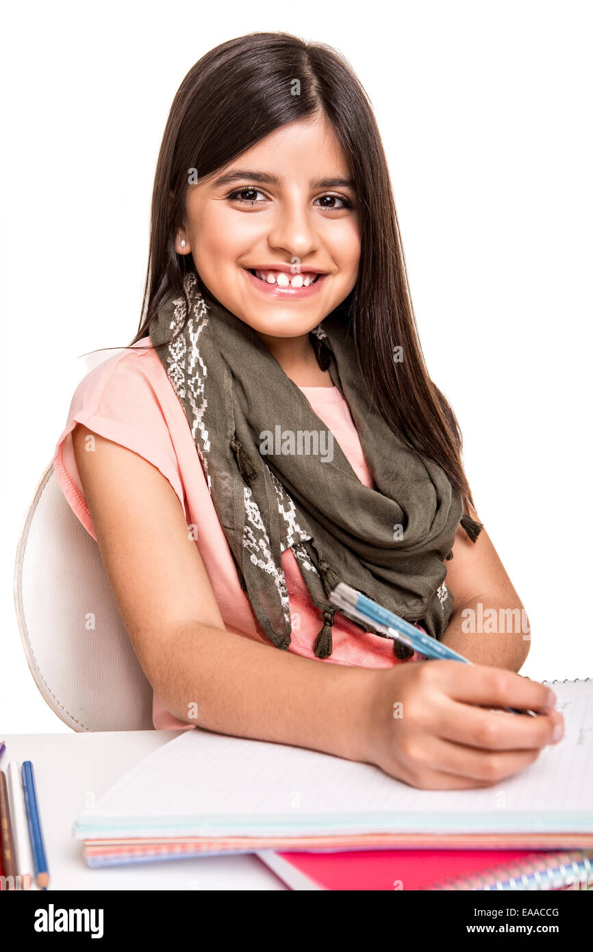 Cute little girl studying and smiling on desk Stock Photo - Alamy