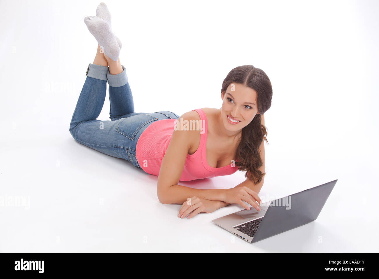 Beautiful young woman in a red vest and blue jeans with laptop Stock ...
