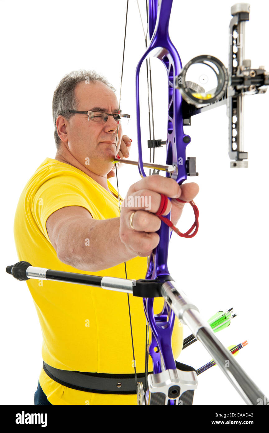 Man with yellow shirt and jeans aiming with a bow and arrow in close up Stock Photo