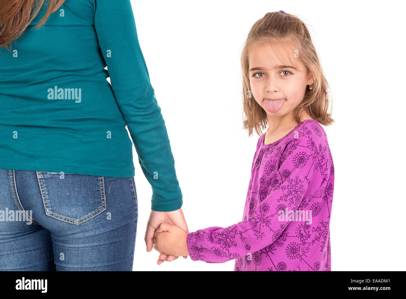 Young girl making faces and holding her mother's hand Stock Photo