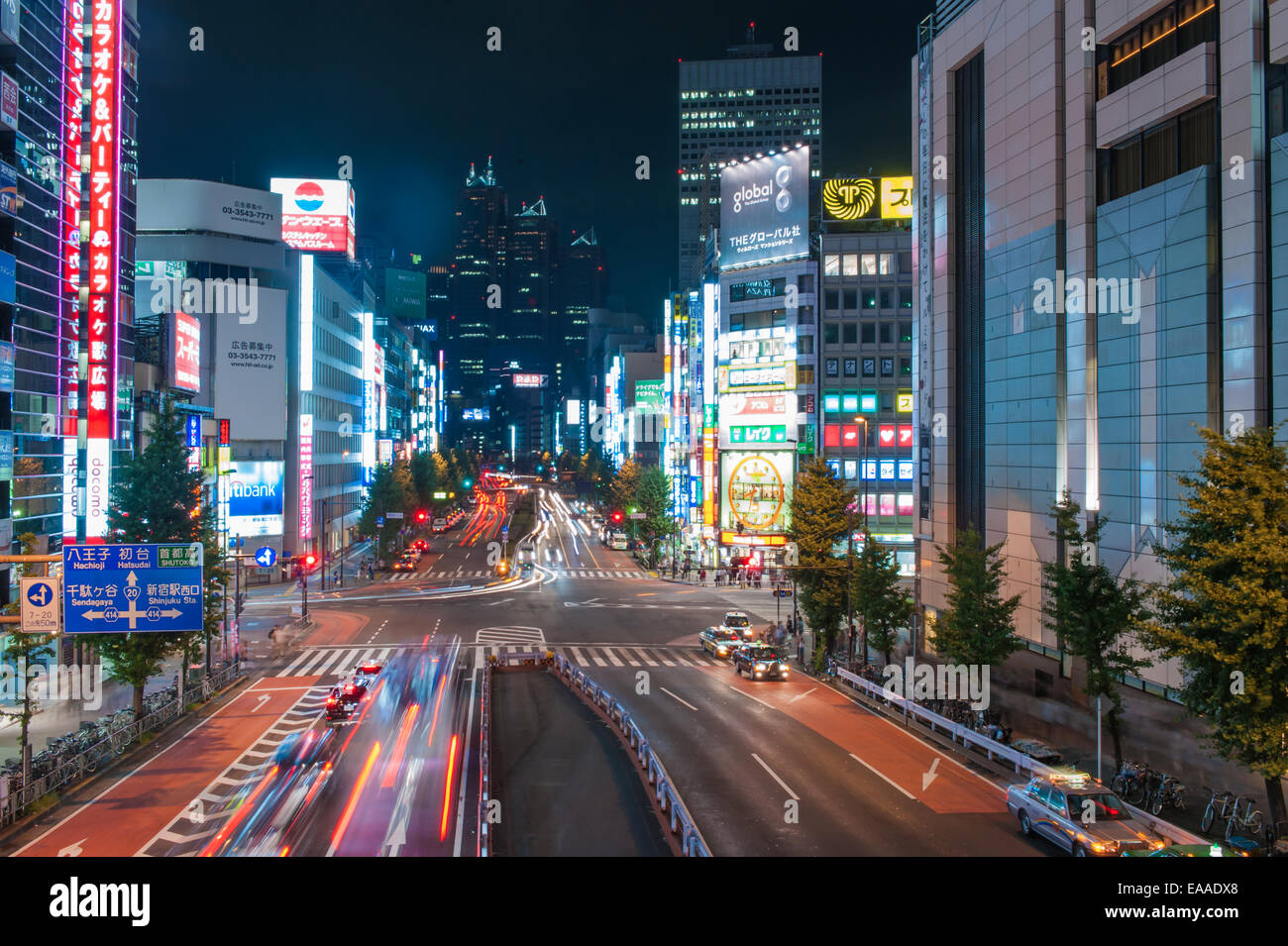 Shinjuku with traffic on Yasukuni Dori Street, and Kabukicho entertainment district at night, Tokyo - Japan Stock Photo