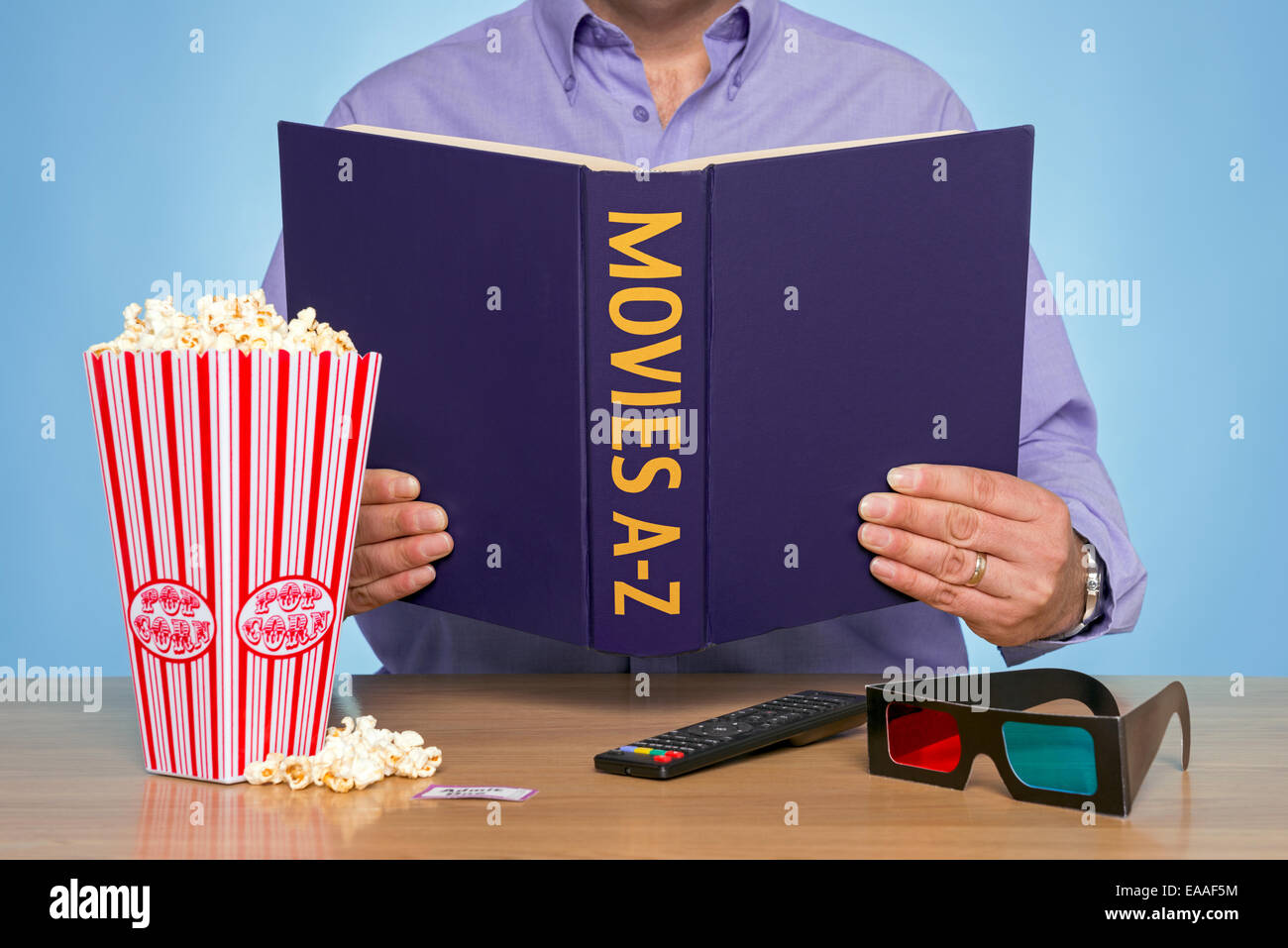 A man sat at a table reading a MOVIES A-Z book Stock Photo