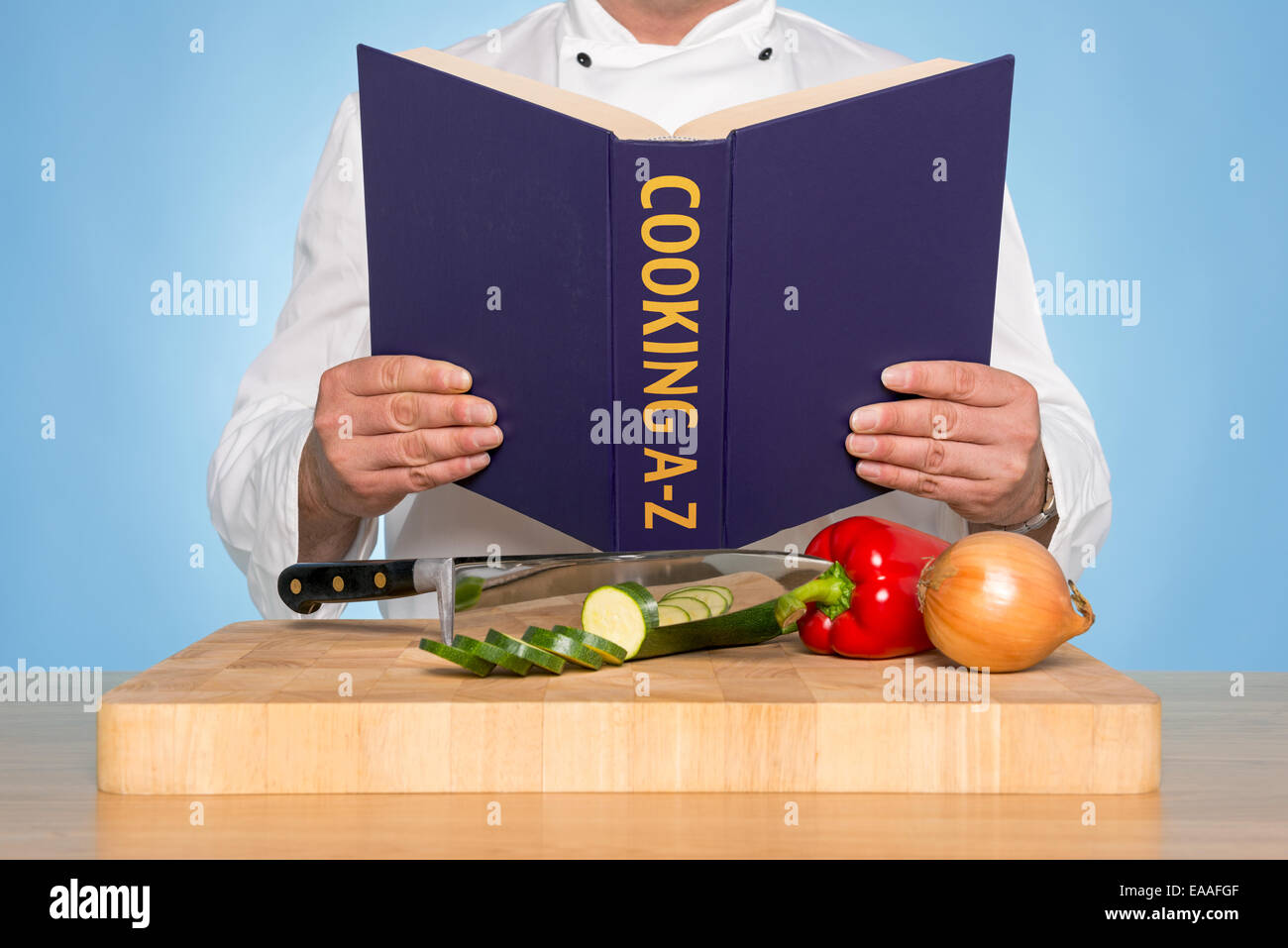 A chef reading a COOKING A-Z book Stock Photo