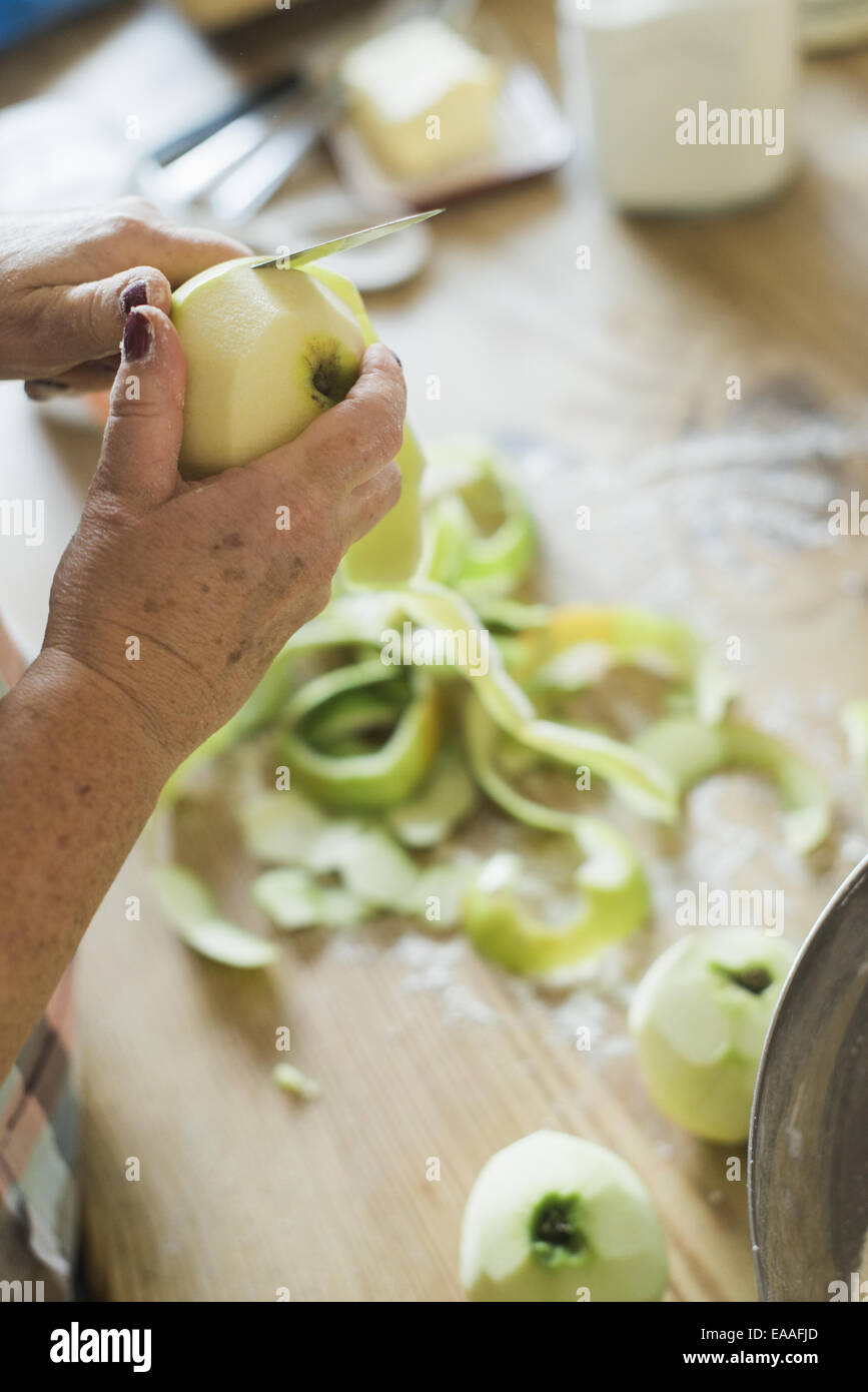 A woman peeling a green skinned apple. Stock Photo