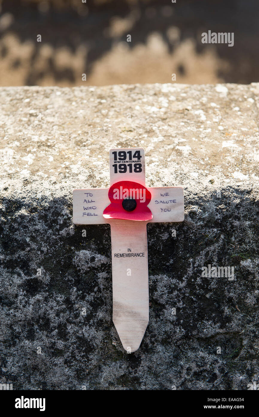 London, UK. 10th November, 2014. A single anniversary wooden cross with a red poppy place on a wall at The Tower of London Crowds flocked to see the 888.246 ceramic remembrance poppies in the moat around the Tower of London in memory of those soldiers killed Credit:  Rena Pearl/Alamy Live News Stock Photo
