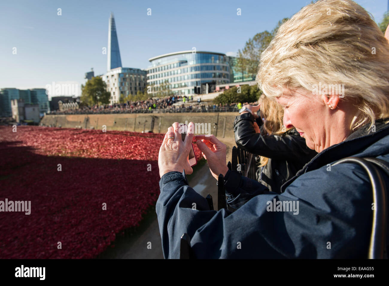 London UK Tower of London. Tourist visiting and taking photos of the remembrance ceramic red poppies on 100th anniversary of WW1 Stock Photo