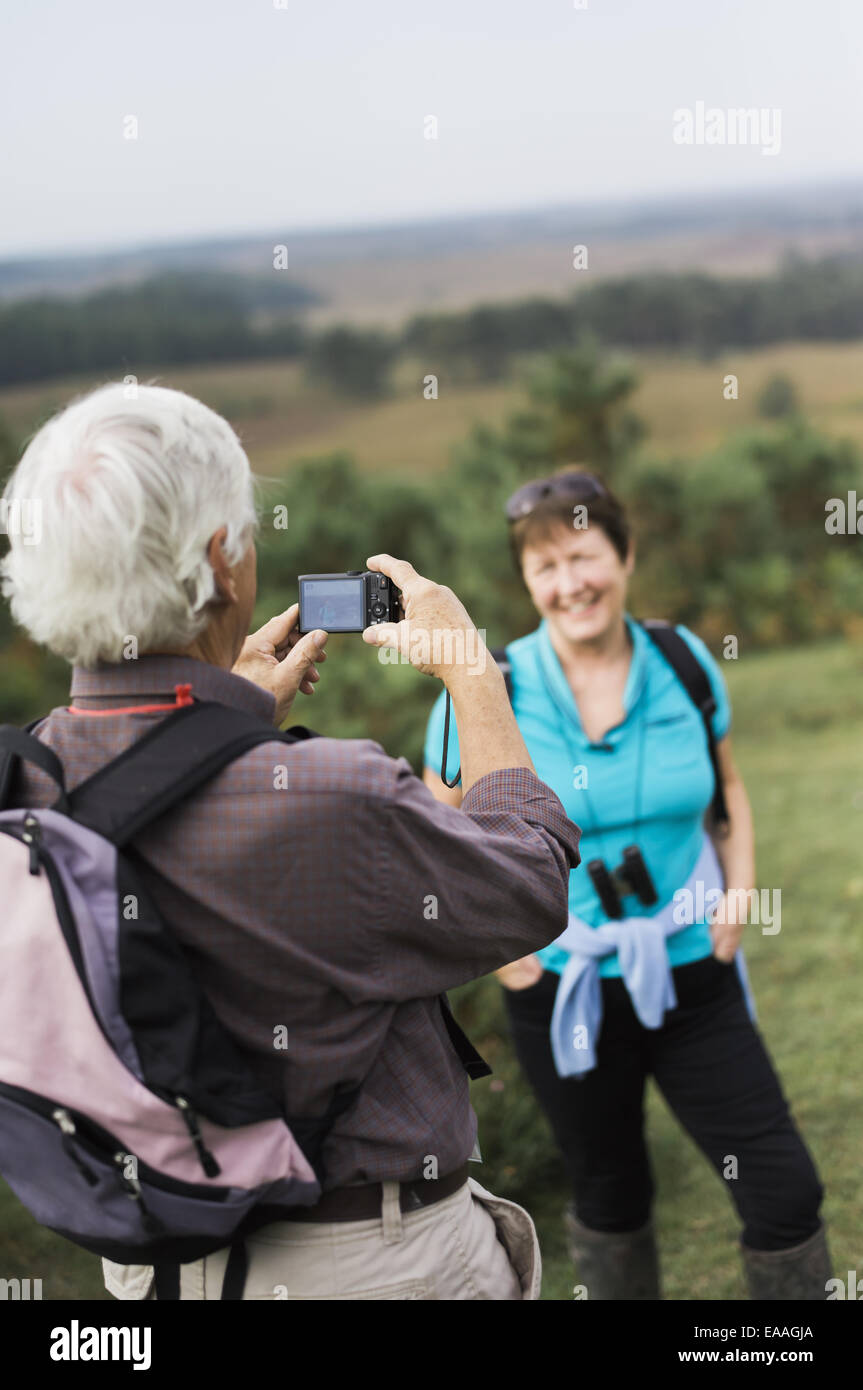 A mature couple taking photographs while out walking. Stock Photo