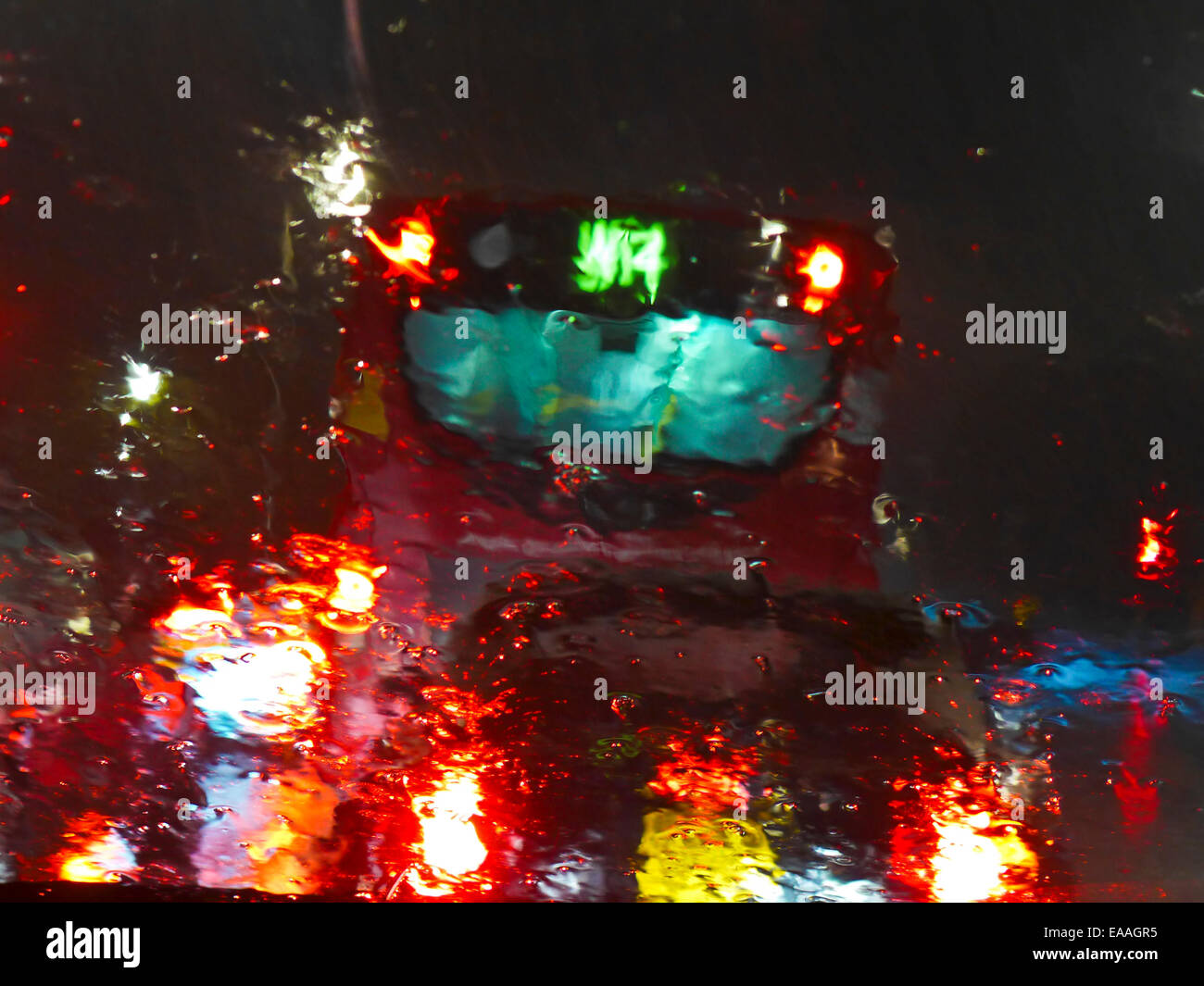 Photographed through a rain covered car windscreen a bus and car lights. Stock Photo