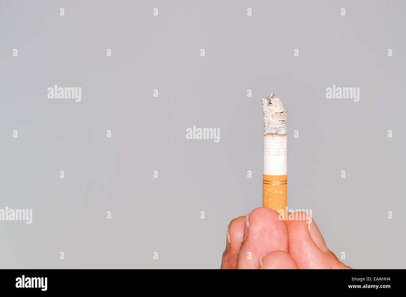 Closeup of a burning cigarette held between fingers Stock Photo Alamy