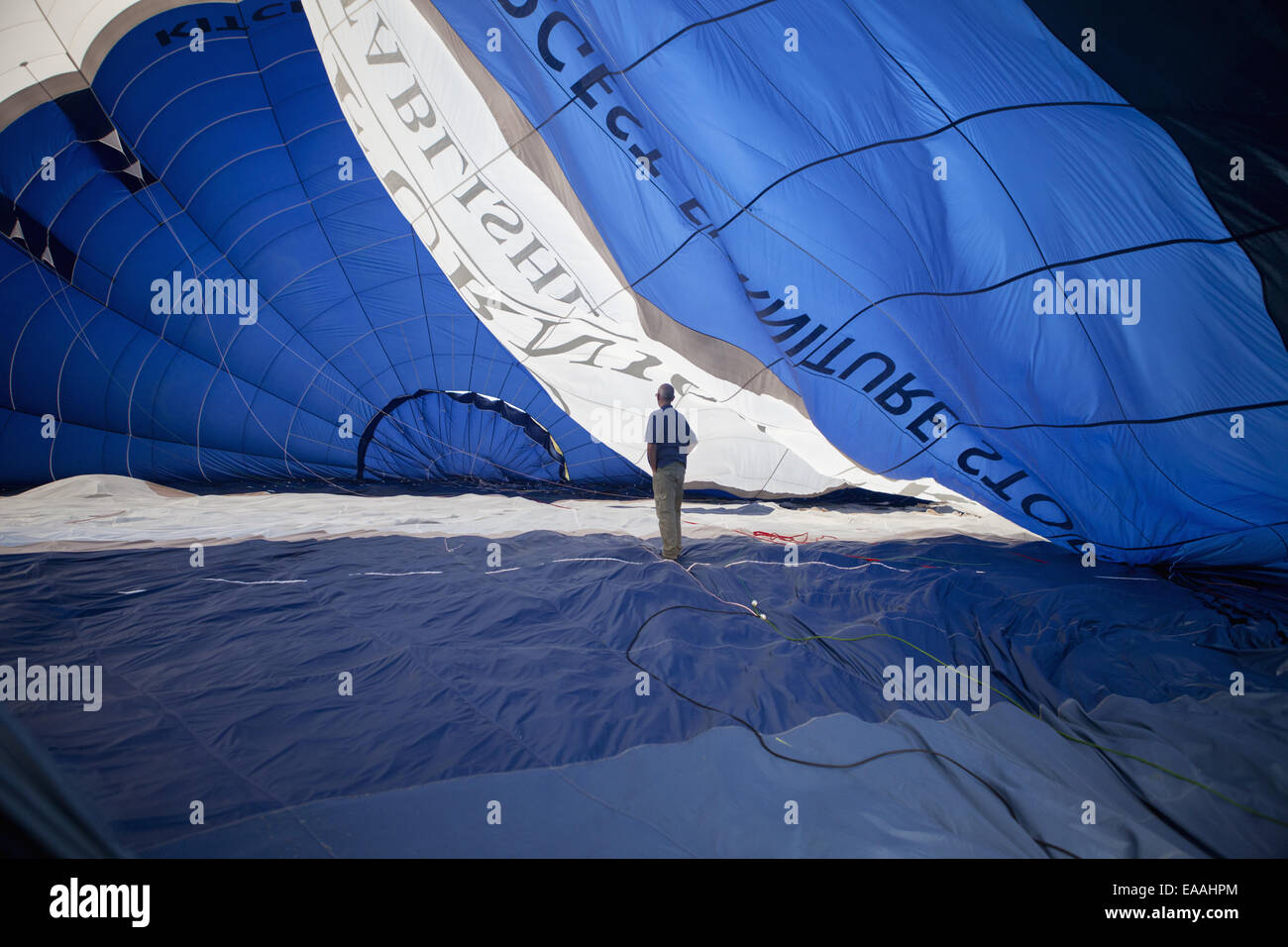 Man standing inside a partially inflated hot air balloon. Stock Photo