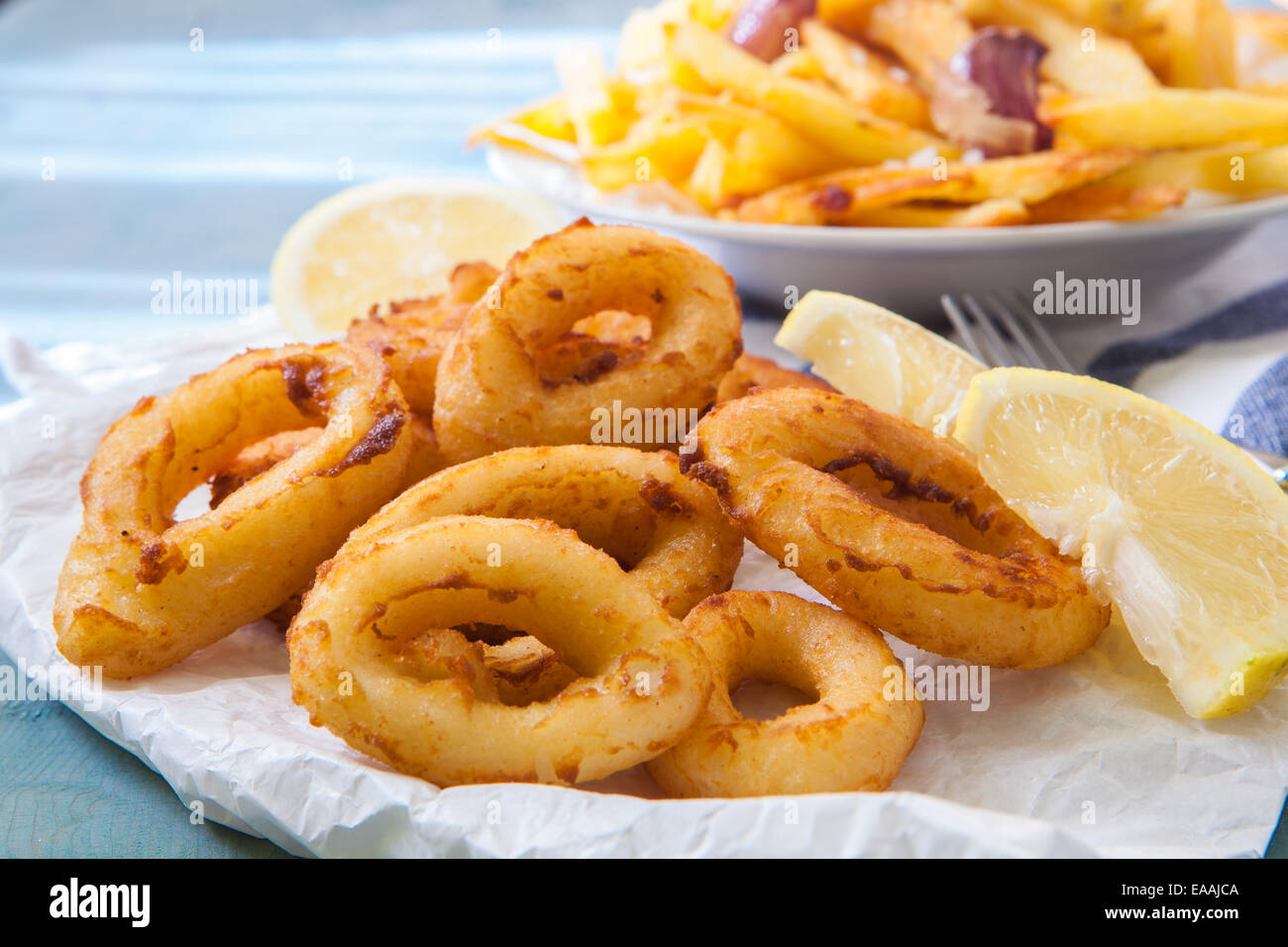 some calamari rings deep fried with lemon and fries Stock Photo