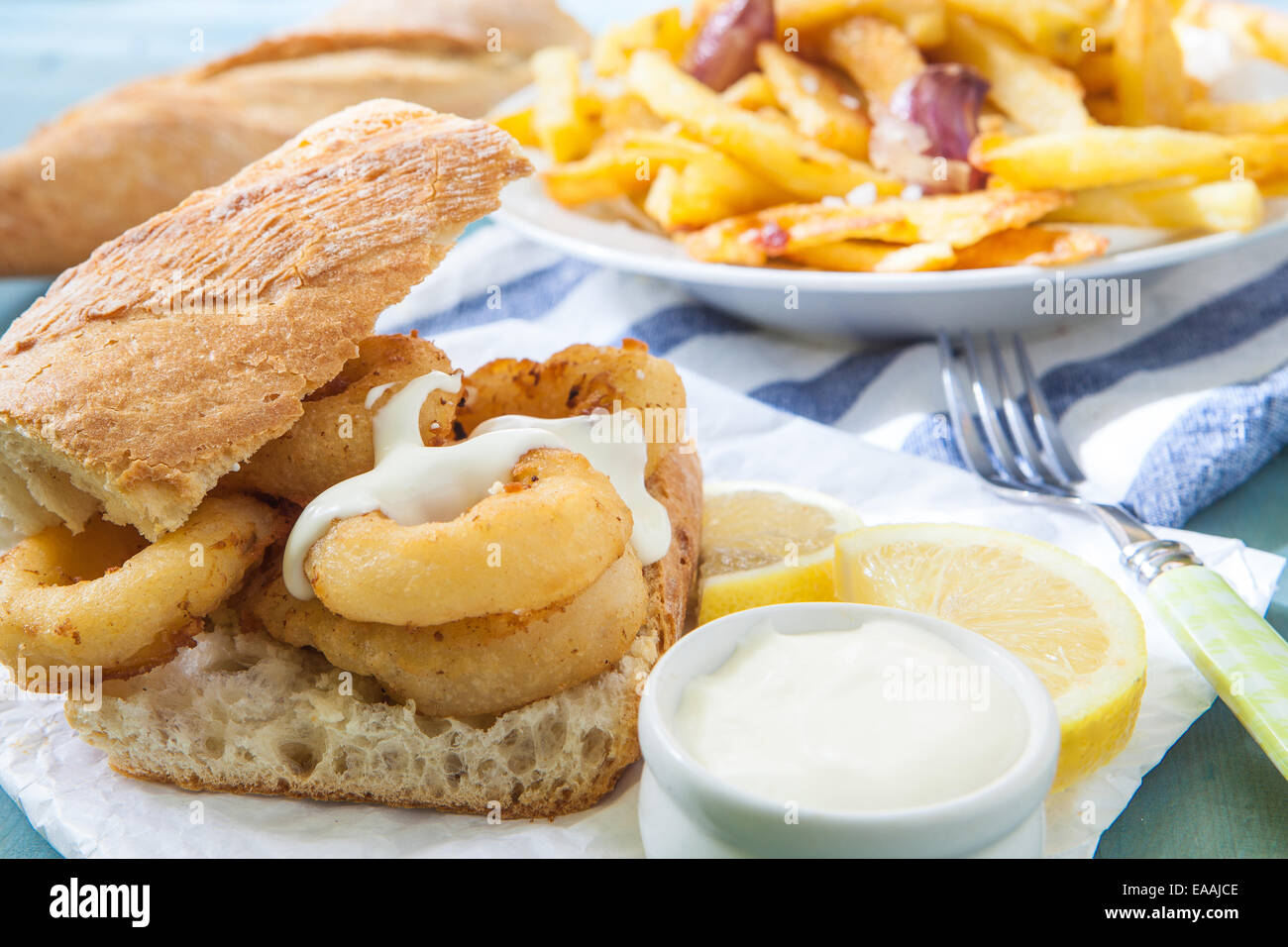 deep fried calamari on bread with sauce and fries Stock Photo