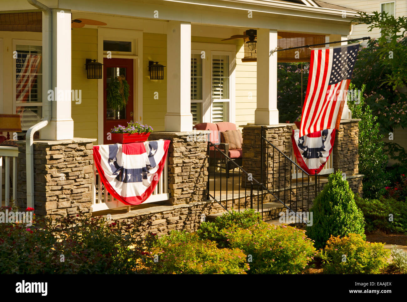 An American Flag and buntings hang from a front porch of an upscale ...