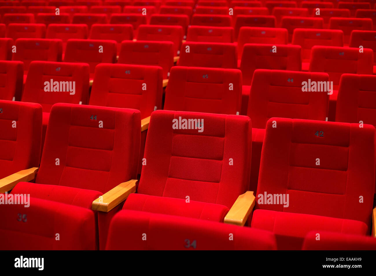 Red and empty theater seats in a row Stock Photo