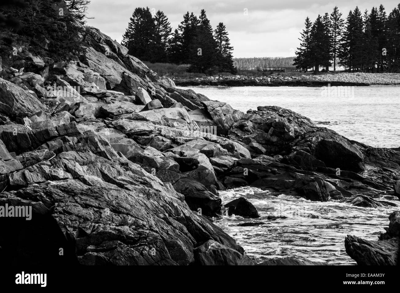 Seascape vista looking past a rocky shore to an island. Stock Photo